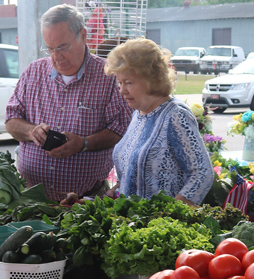 People buying fresh vegetables at a farmer's market in Wilson, NC - Discover Wilson